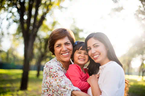 Two women hold and hug small girl